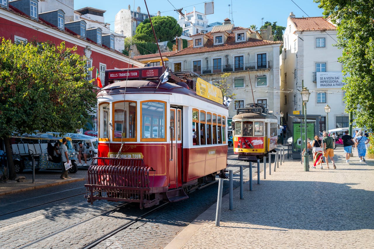 Vintage trams in Lisbon's historic Alfama district, showcasing iconic architecture and summer sightseeing in Portugal.